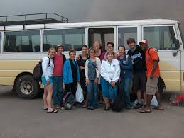 A group of people standing in front of a bus

Description automatically generated